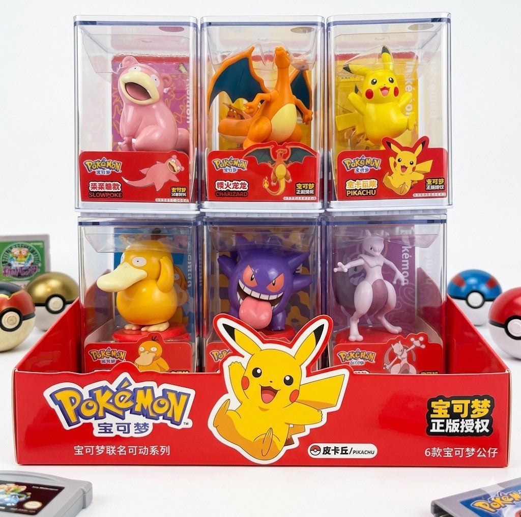 Premium Pokémon display figures in clear acrylic cases featuring Pikachu, Charizard, Gengar, Mewtwo, Psyduck, and Slowpoke